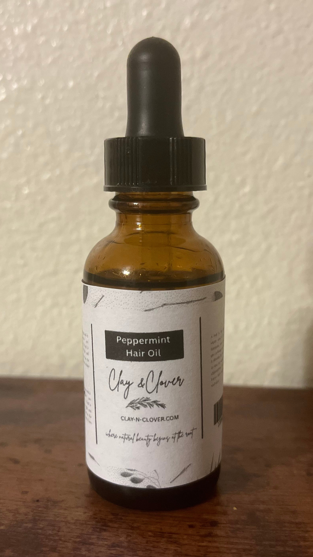 “Clay-N-Clover Peppermint Hair Oil in amber bottle — refreshing natural scalp oil infused with peppermint, olive oil, and vitamin E to stimulate growth and soothe dryness.”